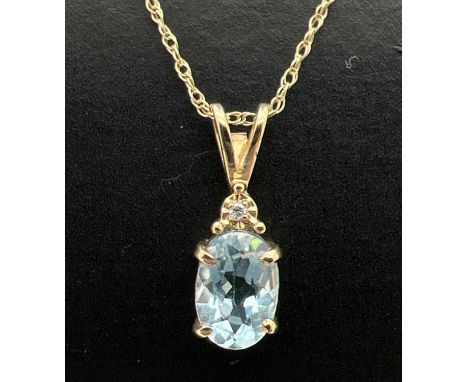 A 9ct gold blue topaz and diamond set drop pendant on an 18" fine Singapore style chain with spring clasp. Pendant set with a