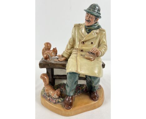 Royal Doulton ceramic figurine "Lunchtime" HN2485, of a man seated at a park bench feeding squirrels. Approx. 19.5cm tall x 1