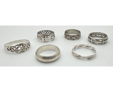 6 silver and white metal band style rings. To include pierced work buckle ring, a twist design band and a star decorated band