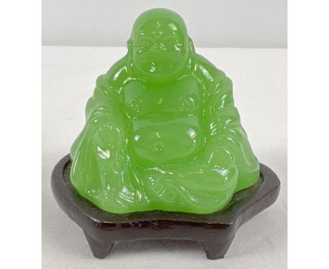 A small carved green jade sitting Buddha figure on a small wooden stand. Figure approx. 5.5cm tall. 