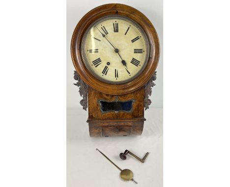 A walnut veneer wooden cased antique wall handing clock with striking bell to top. Carved floral detail to both sides. Glass 