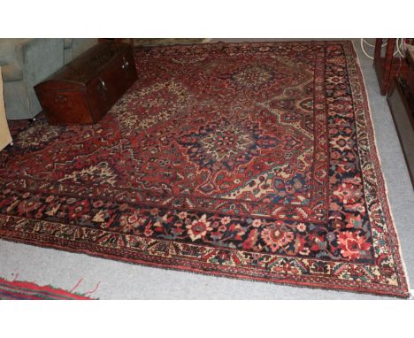 Bakhtiari carpet, of unusual size, the madder field with columns of medallions enclosed by indigo borders, 400cm by 380cm 