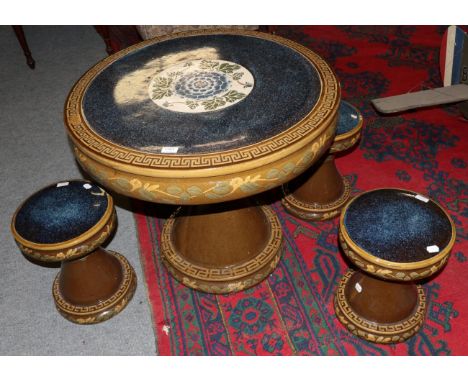 A Chinese ceramic circular pedestal table and three matching stools with foliate decoration