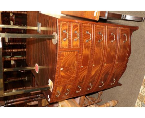 A reproduction mahogany bowfront chest of drawers, in Regency style, with four small drawers surrounding a central deep drawe