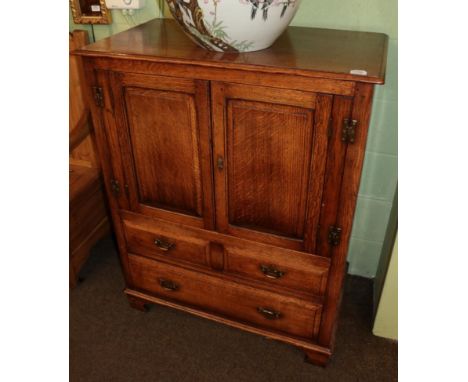 A reproduction oak cupboard, with moulded cupboard doors above two short and one long drawer, on bracket feet, 91cm by 51cm b