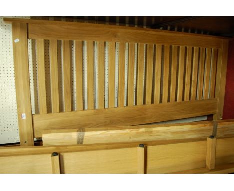 A contemporary light oak slatback kingsize bedstead, having side rails and slats