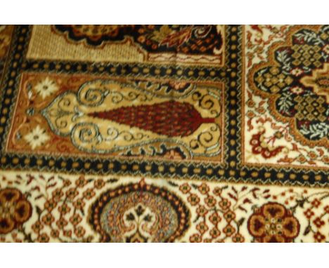 A machine woven Persian style woollen carpet having boxed reserves to include flowers, objects and exotic birds, 410x300cm