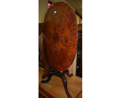 An antique yew wood and further specimen wood radial veneered and cross banded oval tilt top pedestal tripod table 