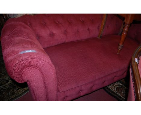 An Edwardian mahogany framed and red button back upholstered drop end three-seater sofa