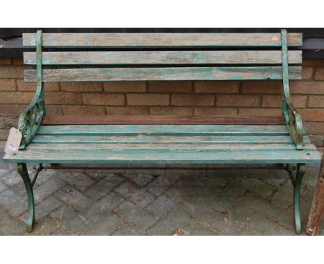 A green painted cast metal and slatted teak two seater garden bench