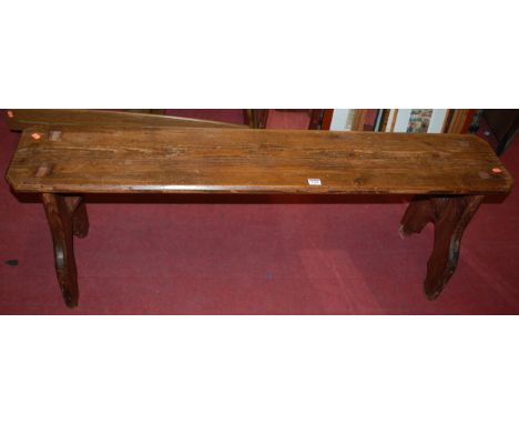 A stained pine bench, of joined construction, with faceted edges, w.137cm