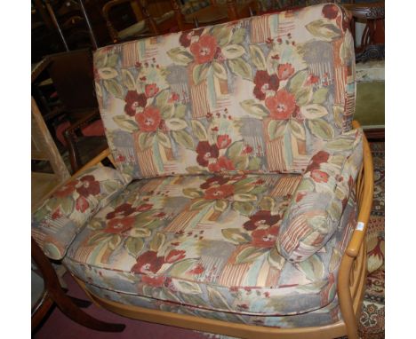 A contemporary Ercol light elm and floral cushion upholstered two seater sofa