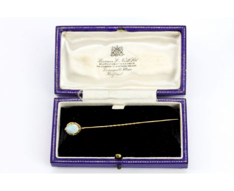 A boxed antique 19th century yellow metal (tested 18ct gold) stick pin set with an oval cabochon cut opal and rose cut diamon