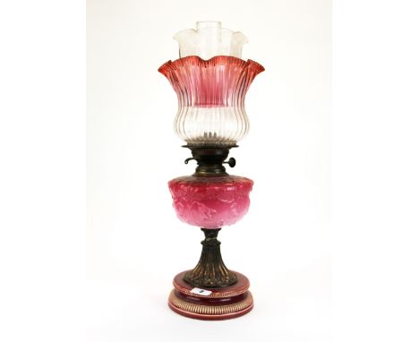 A 19th century oil lamp with pink opaline glass well, cranberry frilled shade and ceramic base, H. 56cm. together with a furt