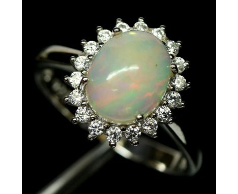 A 925 silver cluster ring set with a cabochon cut opal surrounded by white stones, (O.5).