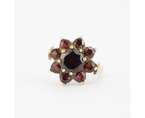 A large vintage silver gilt (worn hallmark) ring set with round cut garnets, (N).