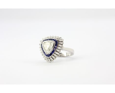 A large 18ct white gold ring set with a large trillion cut diamond, approx. 1.95ct, surrounded by sapphires and baguette cut 