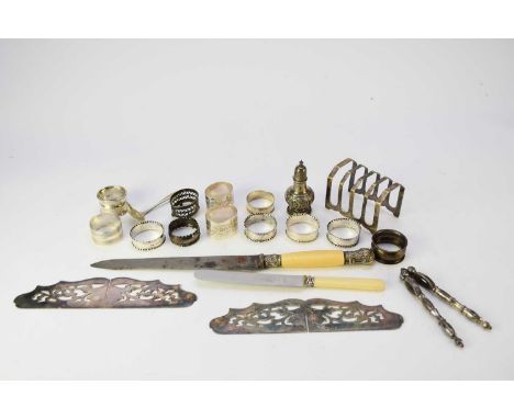 A collection of fifteen sliver napkin rings, various dates and makers, together with a silver pepper pot, two pairs of silver