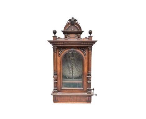 A German walnut coin-operated 19.5in disc polyphon, circa 1880-90, the cabinet with shell cresting and turned pilasters flank