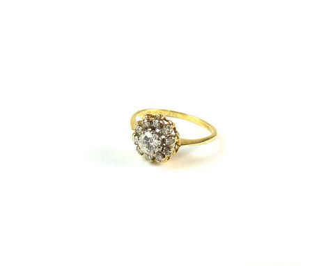 An 18ct gold diamond cluster ring, the central brilliant cut diamond claw set within a border of ten eight cut diamonds, ring