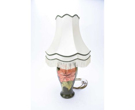 A large Moorcroft table lamp in the Hibiscus pattern, dark green groundof baluster form, with shade, height excluding fitting