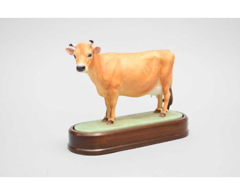 A Royal Worcester Jersey cow; modelled by Doris Lindner, on an oval base set in wooden plinth stand, printed factory marks in