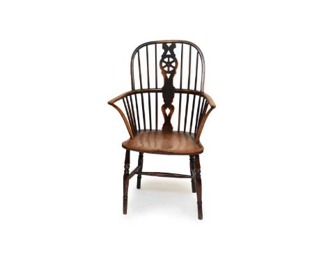 A 19th century wheel back ash Windsor chair, of typical hoop-back form, the shaped splat with pierced 'wheel', the saddle sea