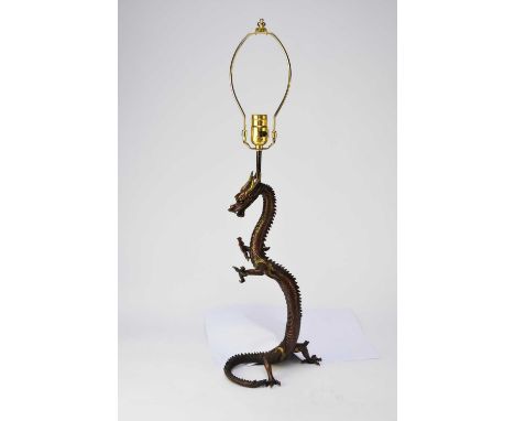 A Chinese bronze dragon table lamp, late 20th century, modelled as a sinuous dragon standing on its hind legs, supporting a l