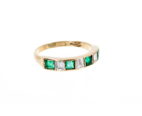 Gold diamond and emerald seven stone ring with three emerald cut diamonds interspaced with four step cut emeralds in a rub ov