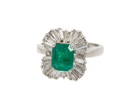 Emerald and diamond 'ballerina' cluster ring with a rectangular step cut emerald surrounded by an undulating border of tapere