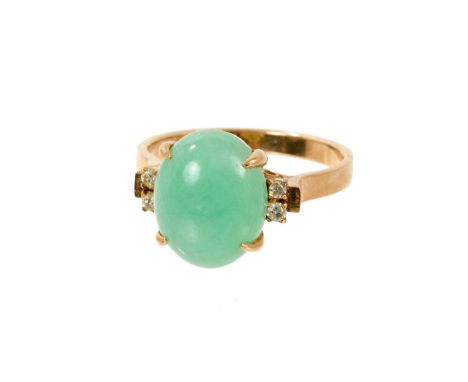 Chinese jade and diamond ring with a oval green jade cabochon measuring 11.7 x 9.5mm flanked by diamonds to the shoulders on 