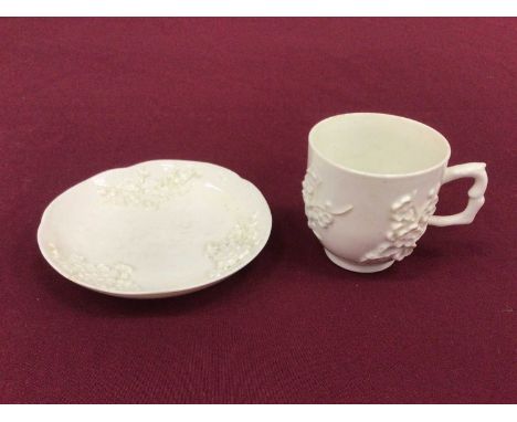 Bow blanc de chine cup and saucer, circa 1752, decorated in relief with prunus blossom, crabstock handle, the saucer 11.5cm d