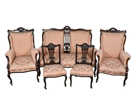 Early 20th century carved mahogany salon suite including sofa, two elbow chairs and two side chairs, each with salmon pink da