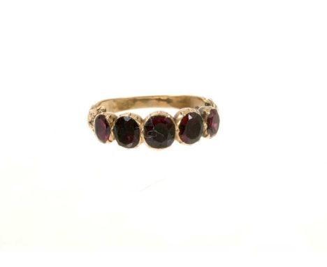 Georgian garnet five stone ring with five oval mixed cut garnets in foil-backed gold collet setting on engraved scroll shank.