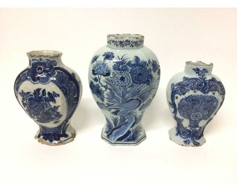 Three 18th century Dutch blue and white delftware vases, each of baluster form and decorated with flowers, 19cm to 24.5cm hig