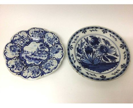  Two Dutch blue and white delftware dishes, 18th/19th century, one of fluted form, 33cm diameter, decorated with landscape sc