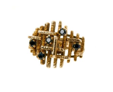 1970s 9ct gold and sapphire cocktail ring of abstract design set with five round mixed cut sapphires on gold textured shank (