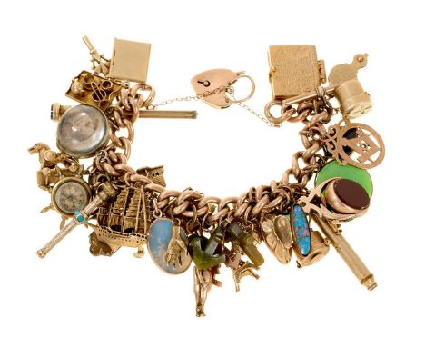 Antique gold charm bracelet with a collection of antique and vintage gold and gilt metal charms to include a WWI 'Fumsup' luc