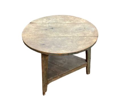 18th century pine framed cricket table on three legs and with an elm shelf and a sycamore top, with traces of original green 