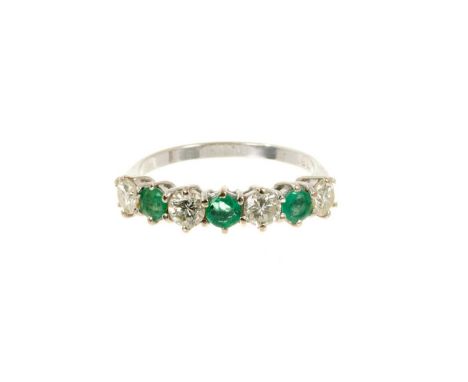 Emerald and diamond eternity ring with a half hoop of three round mixed cut emeralds and three brilliant cut diamonds in 18ct