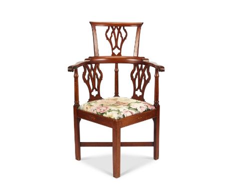 A George III style mahogany corner chair
The Chippendale gothic pierced splats with bowed scrolling arms, above a drop-in sea