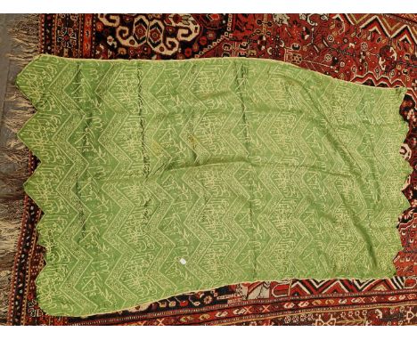 AN ISLAMIC GREEN SILK PANEL WOVEN IN SILVERY GREY WITH CHEVRON BANDS OF SCRIPT.   148 x 84cms.