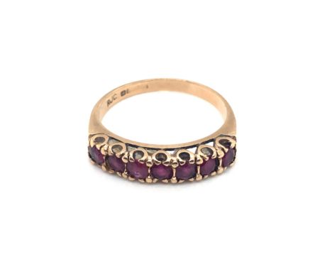 A HALLMARKED 9ct GOLD (MARKS RUBBED) SEVEN STONE RUBY HALF ETERNITY RING. FINGER SIZE R 1/2. WEIGHT 3.0grms.