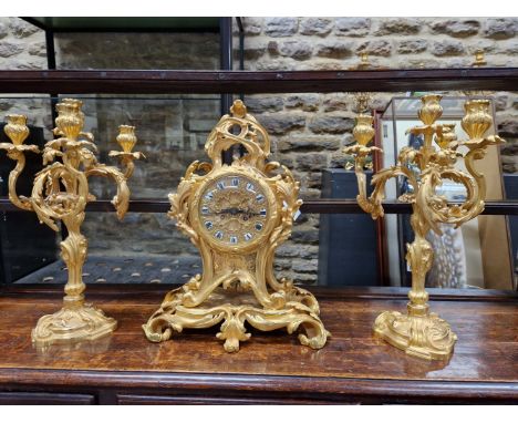 A LEMERLE CHARPENTIER ORMOLU CLOCK GARNITURE, THE CLOCK MOVEMENT STRIKING ON A BELL, THE FACE WITH ENAMEL ROMAN NUMERAL SHIEL