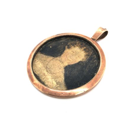 AN ANTIQUE OPEN FRONT PORTRAIT PENDANT. DIAMETER 4.5cms. UNHALLMARKED, ASSESSED AS 9ct GOLD. GROSS WEIGHT 9.49grms. 