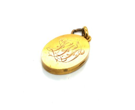 AN ANTIQUE OVAL PORTRAIT LOCKET WITH MONOGRAM ENGRAVING TO BOTH FRONT AND REVERSE. UNHALLMARKED, ASSESSEED AS 18ct, ONE ATTAC