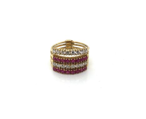 A FOUR ROW RUBY AND CZ TENSION STYLE RING. THE FOUR INDIVIDUAL RINGS WITH A CONNECTING BAR TOWARDS THE BACK. FINGER SIZE LEAD