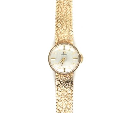 A 9ct HALLMARKED GOLD LADIES OMEGA WATCH ON A MILANESE STYLE BRACELET AND LADDER CLASP. LENGTH 17cms. WEIGHT 22.32grms.