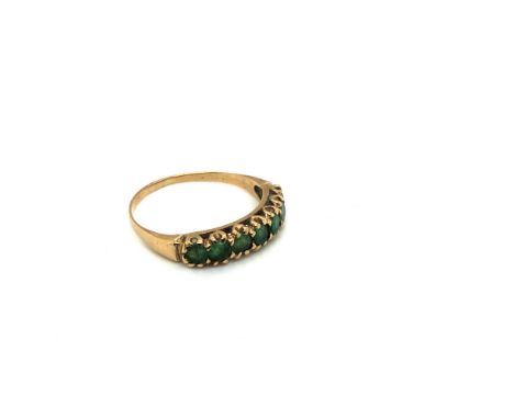 A VINTAGE SEVEN STONE EMERALD HALF ETERNITY RING. UNHALLMARKED, ASSESSED AS 9ct GOLD. RING SIZE R. WEIGHT 1.97grms. 