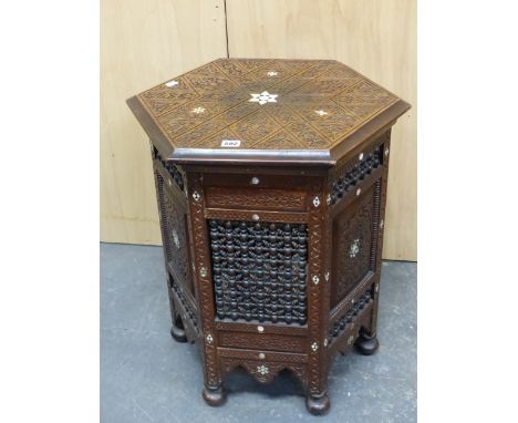 AN ISLAMIC HEXAGONAL TABLE CARVED WITH BLIND FRET FOLIAGE DIAMONDS, TRIANGLES AND BANDS ABOUT MOTHER OF PEARL STARS REPEATED 